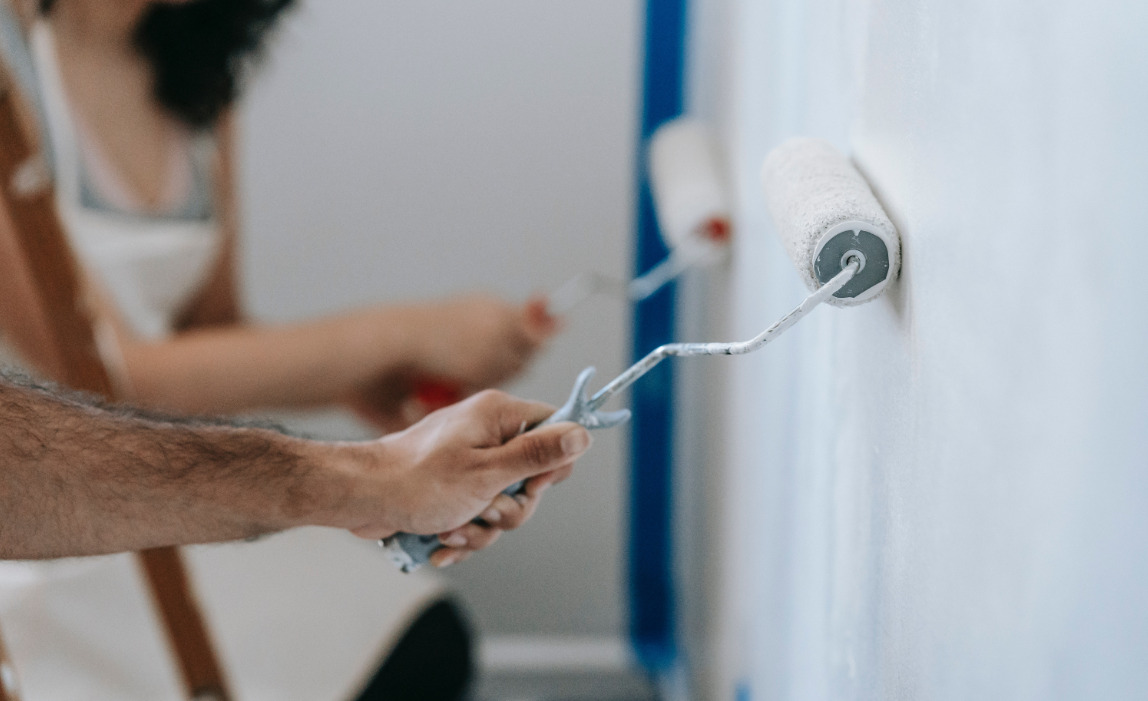 Deux peintres peint le mur avec les rouleaux à peinture